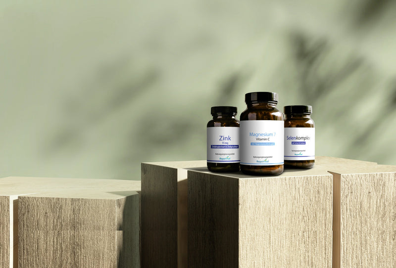 Produktabbildung: Drei RepaVital Nahrungsergänzungsmittel Zink, Magnesium 7 Vitamin C und Selenkomplex auf Holzpodesten.
