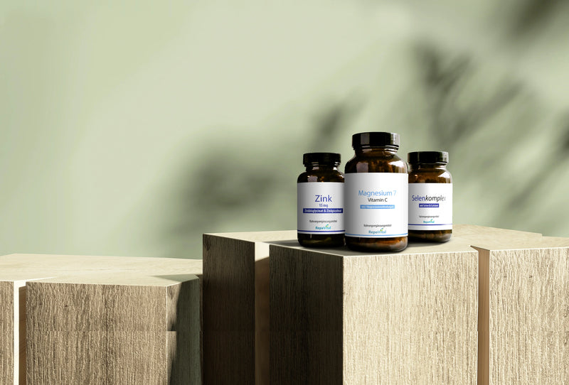 Produktabbildung: Drei RepaVital Nahrungsergänzungsmittel Zink, Magnesium 7 Vitamin C und Selenkomplex auf Holzpodesten.